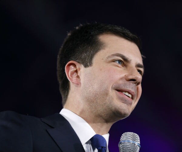 Democratic presidential candidate Pete Buttigieg speaks to an audience in a blue suit and tie.