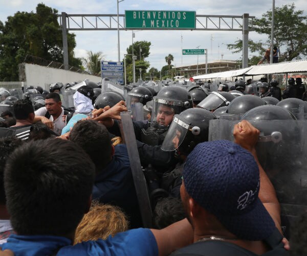 migrant caravan members clash with mexican riot police