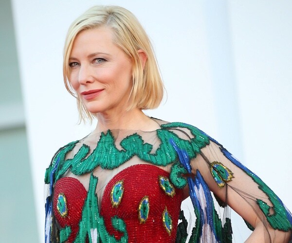 cate blanchett stands on red carpet