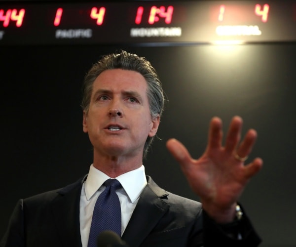 newsom in a black suit and blue tie