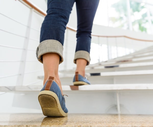 woman walking up a set of indoor stairs