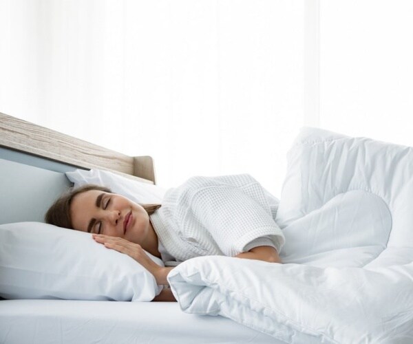 woman sound asleep in bed with white bedding