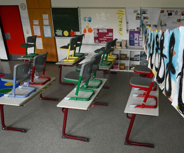 a classroom full of empty desks is seen