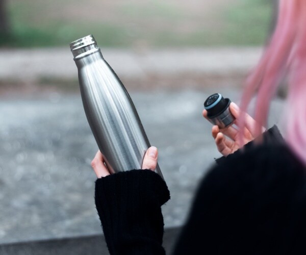 woman holding open reusable water bottle