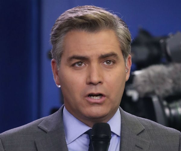 jim acosta speaks into a microphone