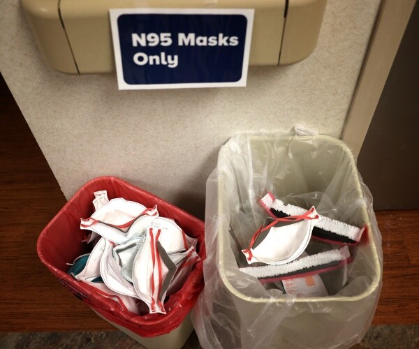 n95 masks in recycling bins one with red plastic and the other with a clear bag