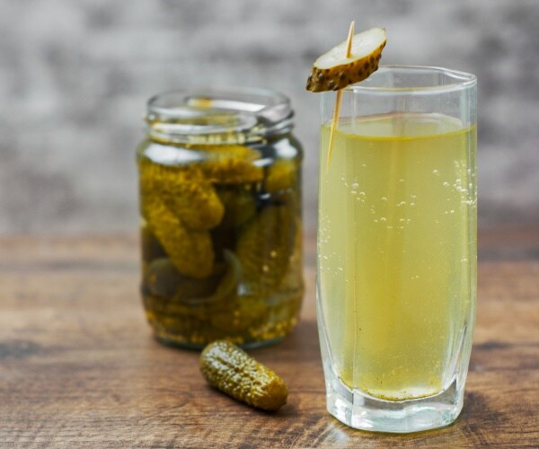 pickles in glass jar, and pickle juice in glass