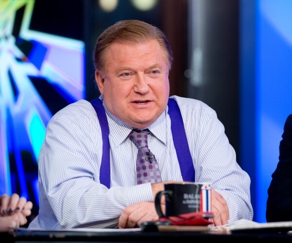 Bob Beckel speaks while sitting at a table