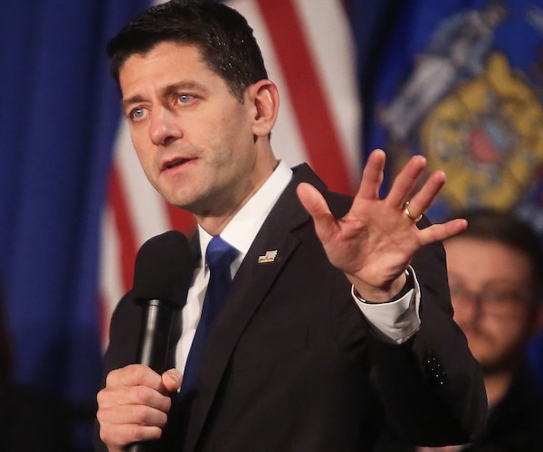 paul ryan holds up his left hand as if to say stop during a speech