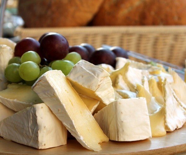 plate with brie cheese and grapes