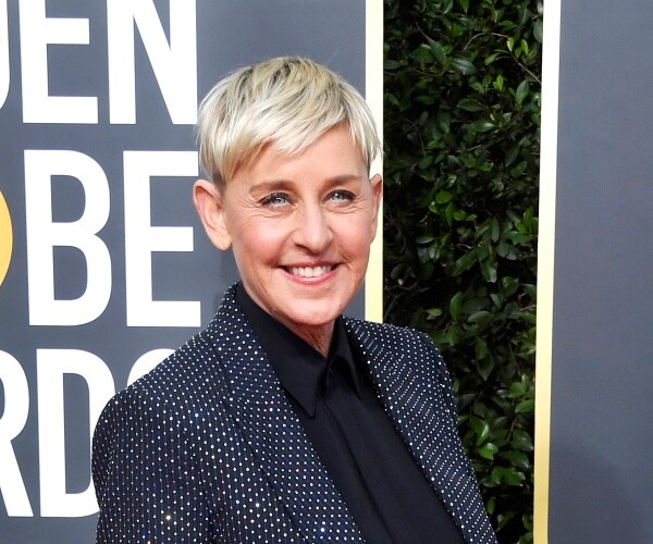 ellen degeneres stands on red carpet