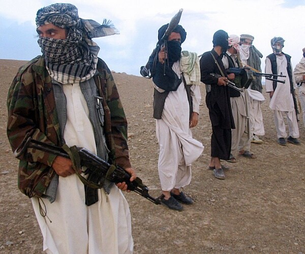 fighters with afghanistan's taliban militia stand on a hillside 