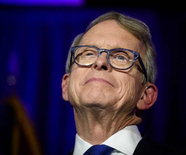 mike dewine in a suit and blue tie looking up