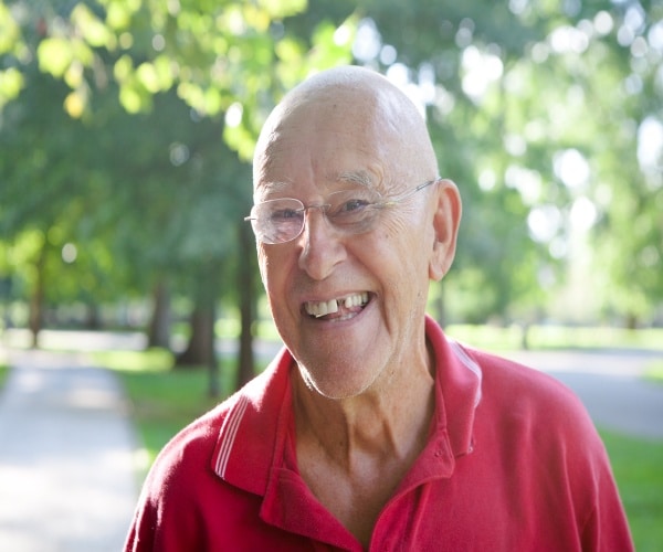 Older man smiling with a missing tooth 