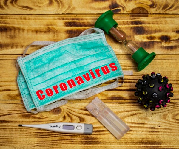 Coronavirus quarantine concept, on a wooden background, medical mask with capsule and virus