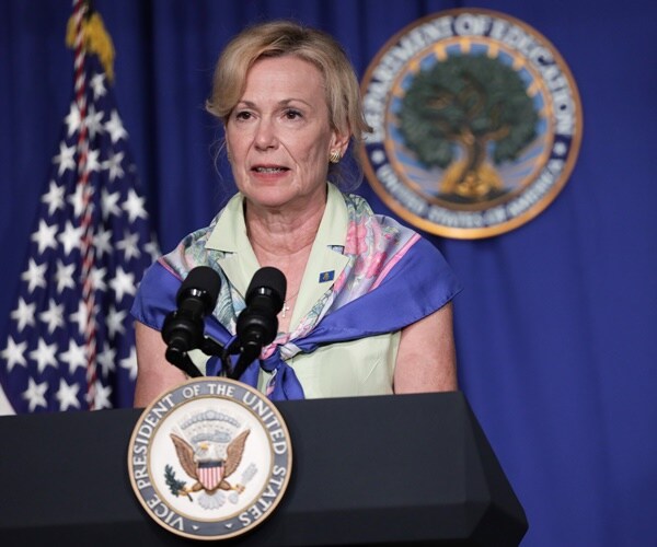 dr. birx speaks at the podium wearing her signature scarf.