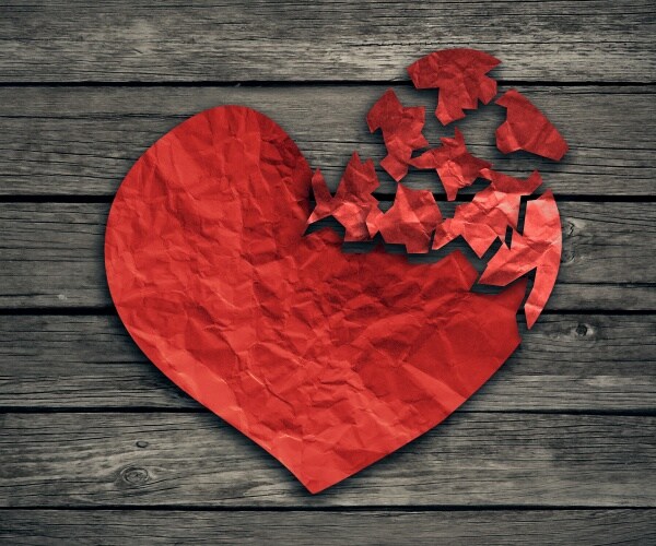 pieces of red paper heart breaking off