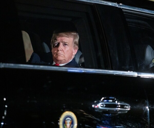 president trump is seen behind a window of the presidential limo