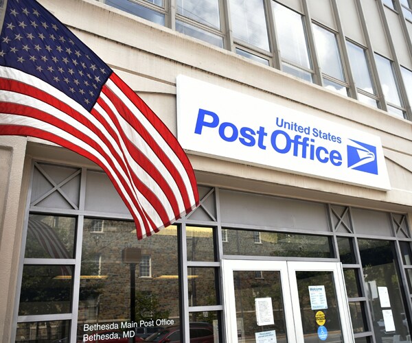 an american flag flies outside a post office