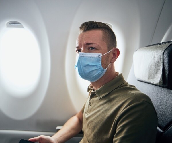 man on plane with mask