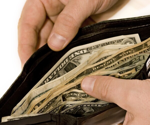 close up view of a wallet full of money (u.s. currency) isolated on a white background 

