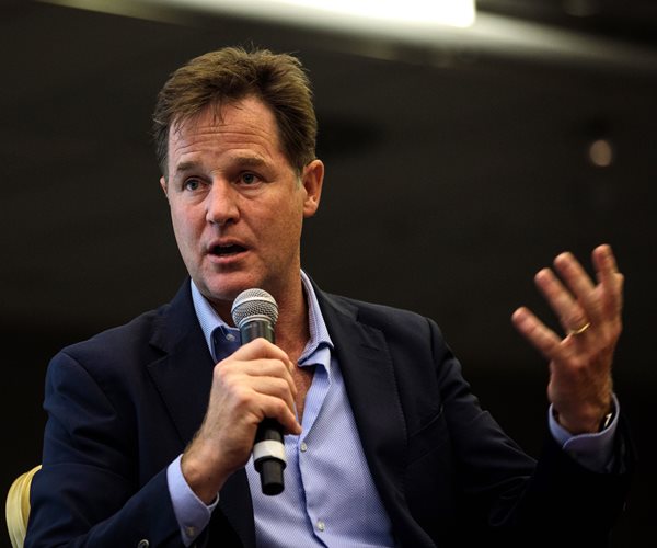 nick clegg speaks with microphone in right hand as he gestures with his left hand