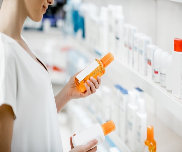 woman in pharmacy choosing sunscreen