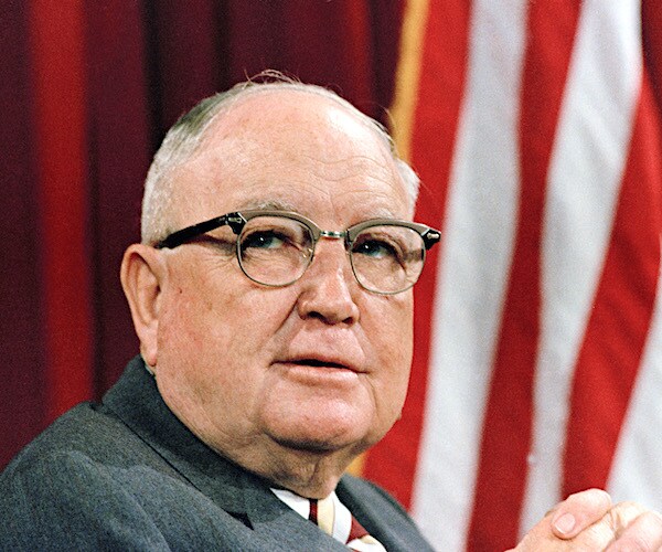 late senator james eastland looks over his right shoulder with an american flag in the background in 1971