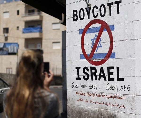 a woman takes a picture of a bds sign on a wall.