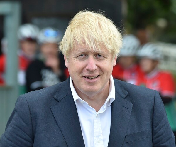 boris johnson stands outside and speaks with people