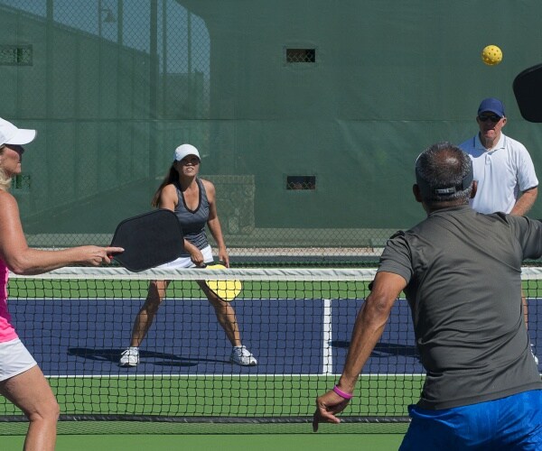 four people playing pickleball