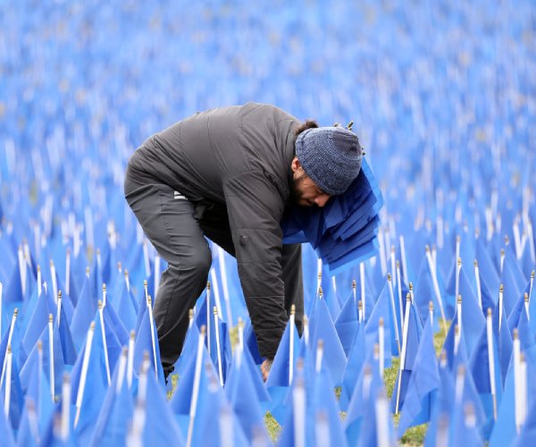 A volunteer places flags at a colorectal cancer awareness event.