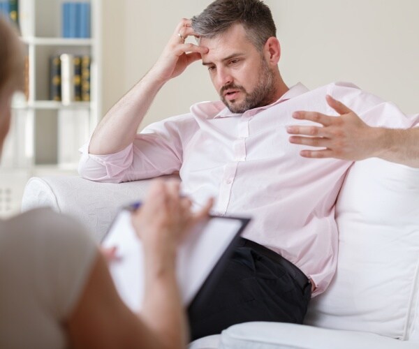 man on couch talking to a therapist