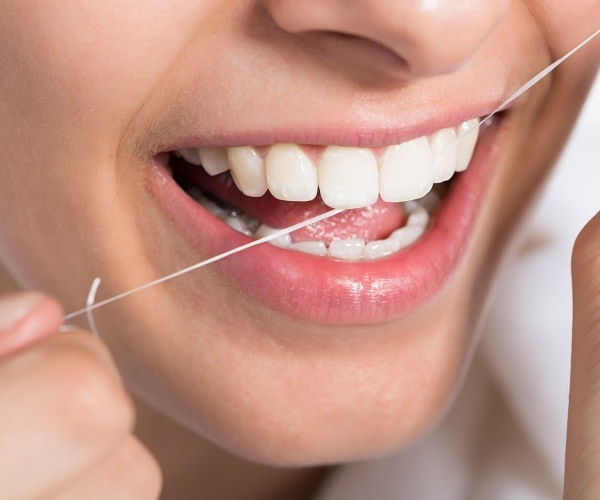 woman flossing teeth