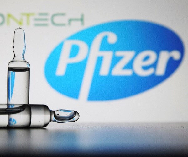 vaccine ampules in front of pfizer logo