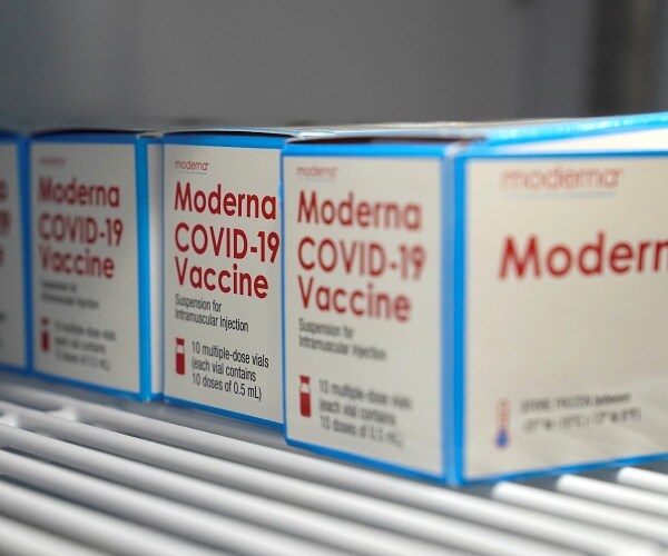 boxes of moderna coronavirus vaccine sit in refrigerator 