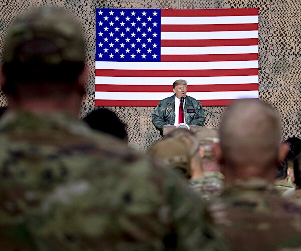 president donald trump address troops in the middle east in front of a large american flag