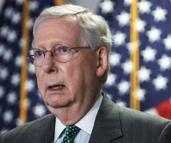 mcconnell in a dark gray suit and green polka dotted tie