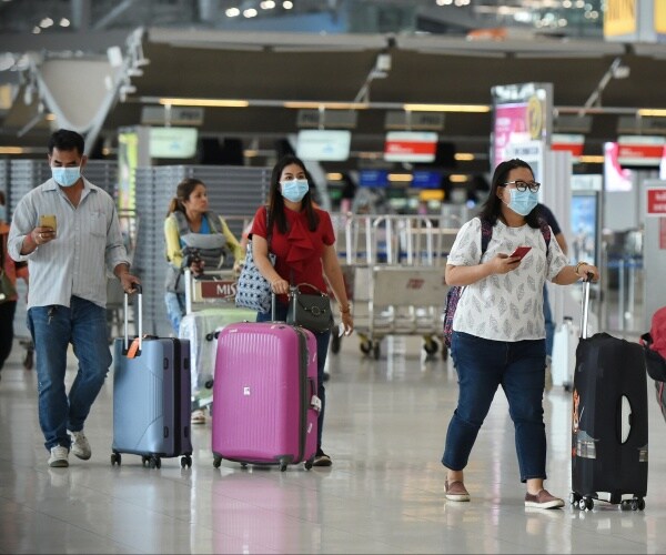 travelers wearing masks in airport