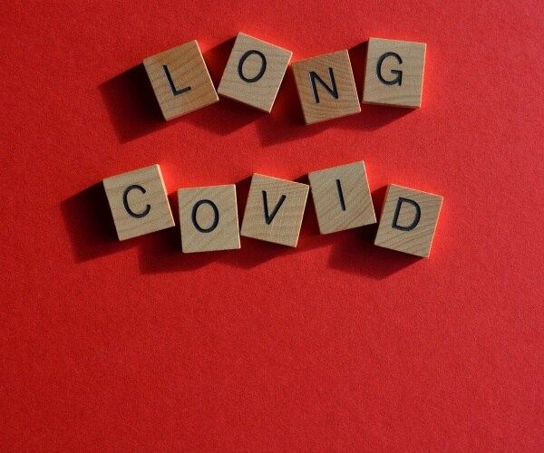 Long COVID spelled out in letter tiles on red background