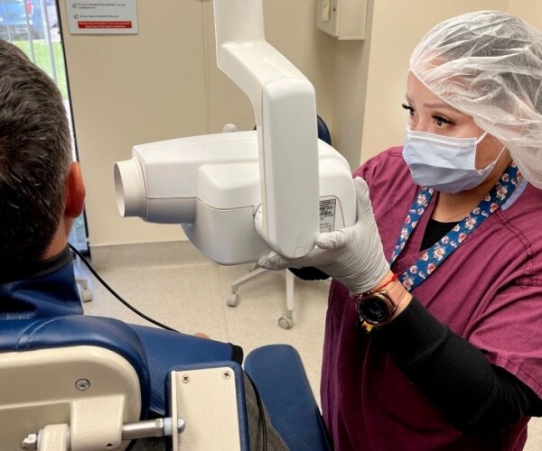 patient wearing lead apron in dentist's office while getting x-rays