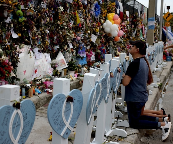 people pray at condo collapse memorial