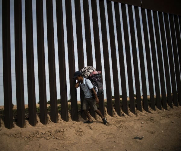 man walks along u.s.-mexico border