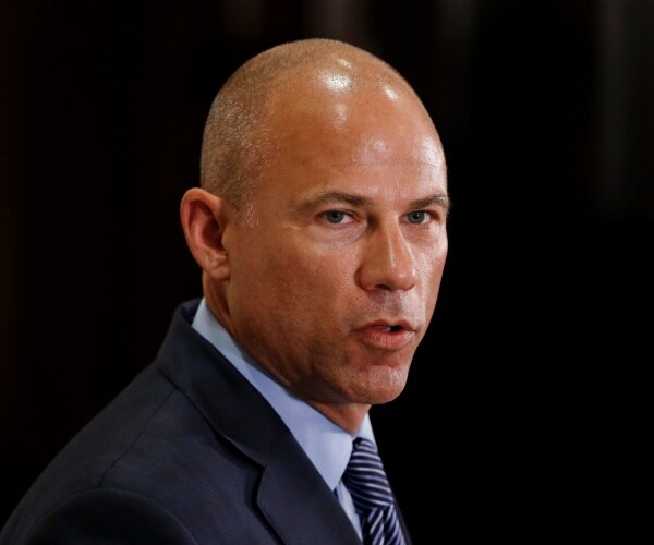 avenatti in a navy blue suit and light blue shirt with striped tie