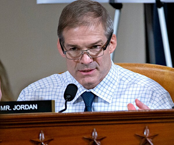 jim jordan, wearing glasses, looks down from a dais during a house intelligence committee impeachment hearing