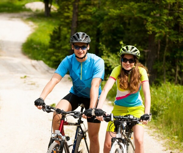 man and woman wearing helmets stopped on bikes