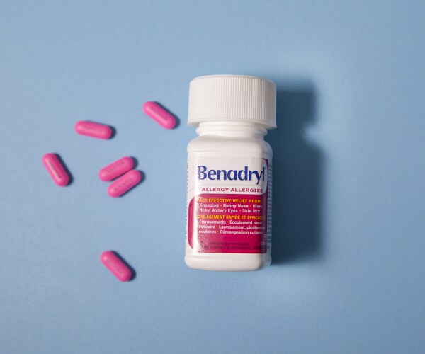 a bottle of benadryl with pills next to it