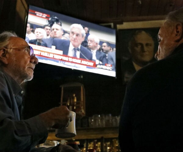 two men sit in tavern watching robert mueller testify on an overhead television