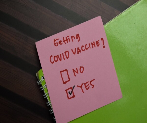 a post it with a check off for Covid vaccine, yes or no