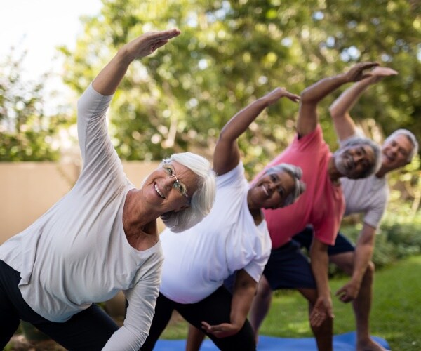 older adults smiling in outside group exercise class